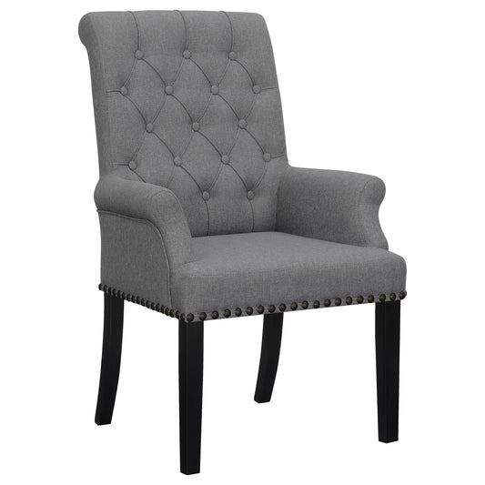Fauteuil à accoudoirs capitonné et recouvert de tissu, avec garniture à clous décoratifs, modèle Alana.